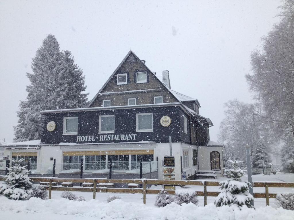 a large building with a hotel in the snow at Hotel Herrloh in Winterberg