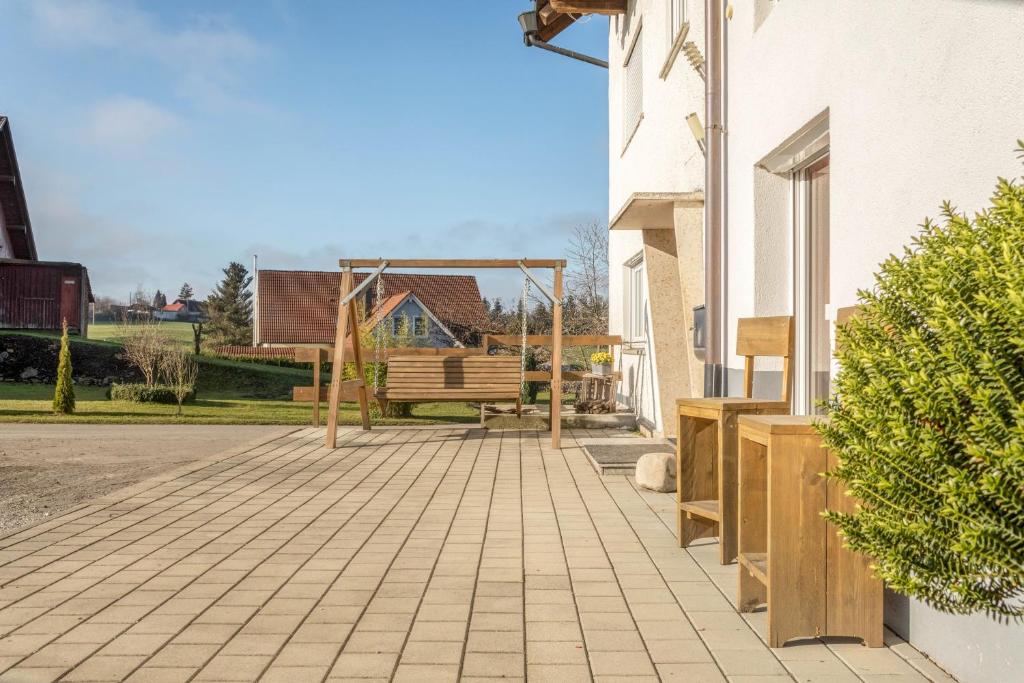 a patio with a swing and a bench at Ferienhof Sauter Lindau in Neukirch