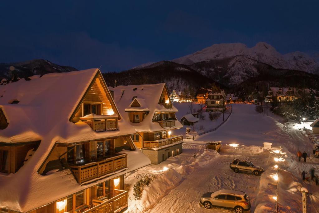 une ville recouverte de neige la nuit avec des voitures dans l'établissement Apartamenty Lipki Park, Sun & Snow, à Zakopane