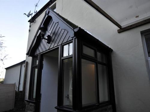 a house with black windows on the side of it at Hoppers Cottage Guest House in Gateshead