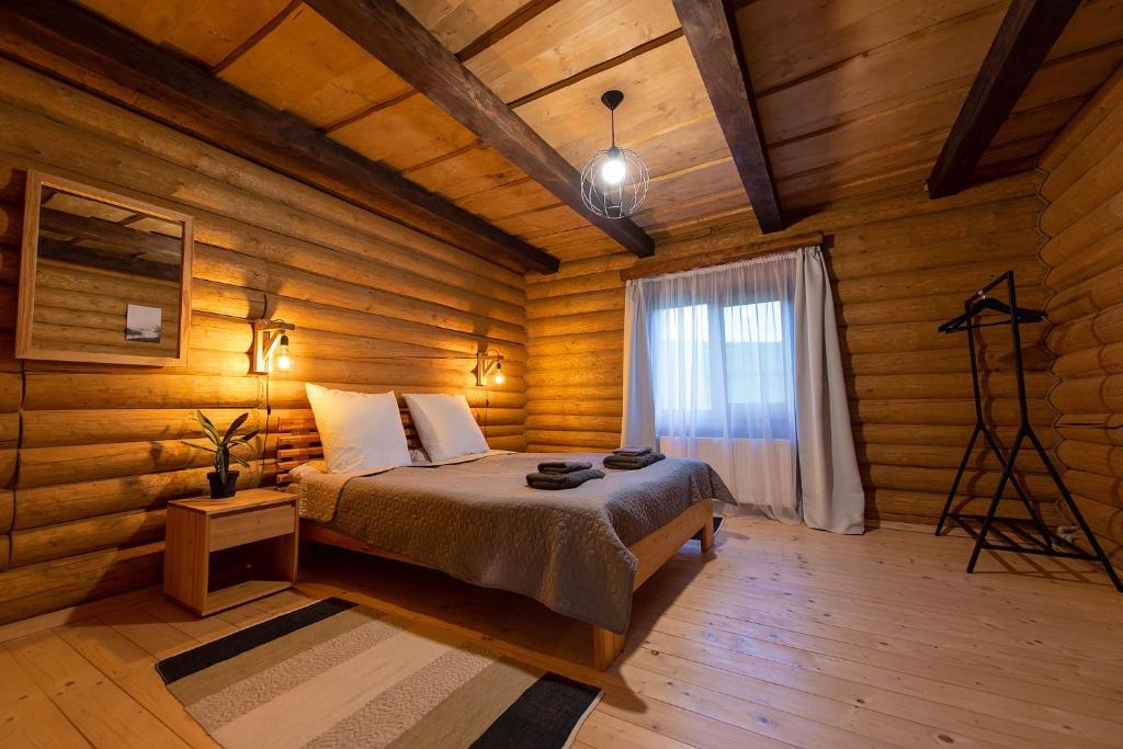 ein Schlafzimmer mit einem Bett in einem Holzzimmer in der Unterkunft Chalet Borzhava in Huklyvyy