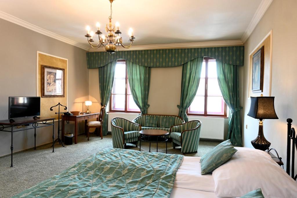a hotel room with a bed and a table and chairs at Hotel Bouček in Kroměříž