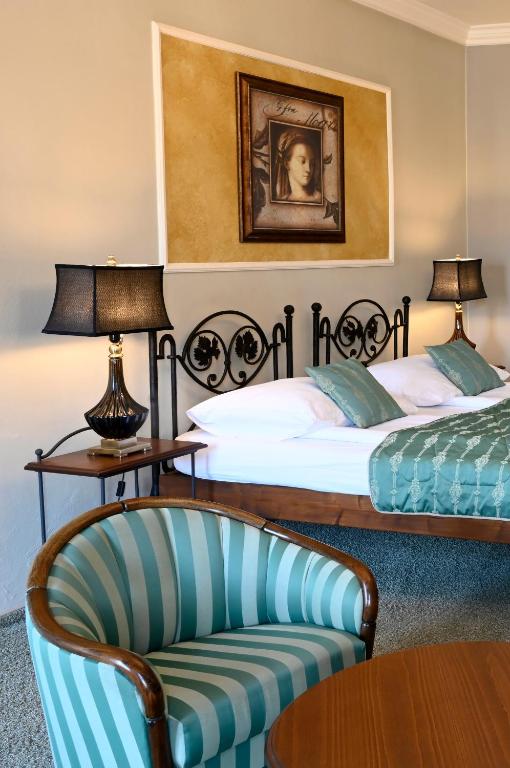a hotel room with two beds and a chair at Hotel Bouček in Kroměříž