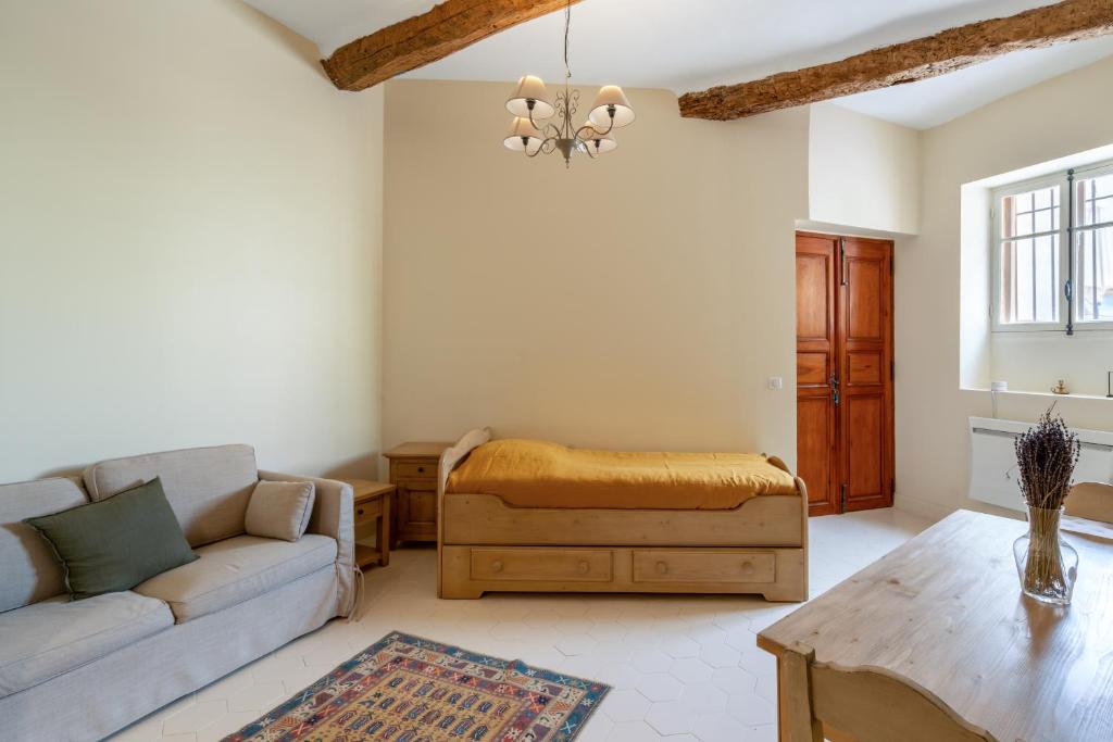 ein Wohnzimmer mit einem Sofa und einem Tisch in der Unterkunft La Maison de Beaumont in Beaumont-de-Pertuis