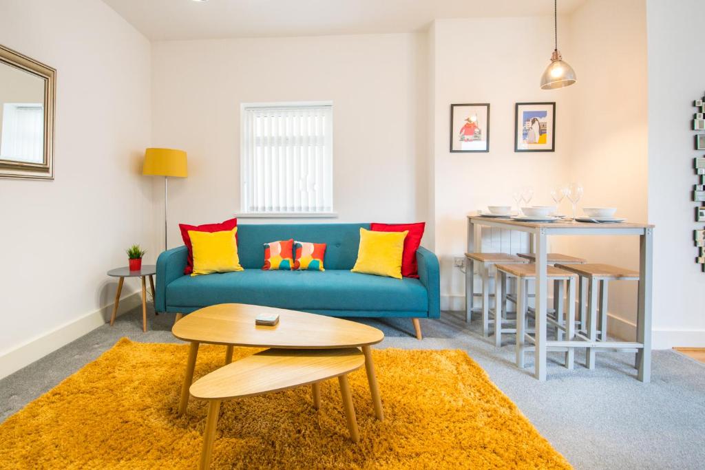 a living room with a blue couch and a table at Detached Coach House near Principality Stadium in Cardiff in Cardiff