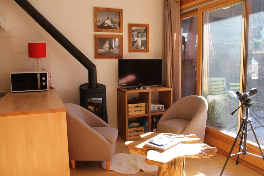 a living room with two chairs and a stove at Comfortable Apartment With Terrace In Chamonix in Chamonix