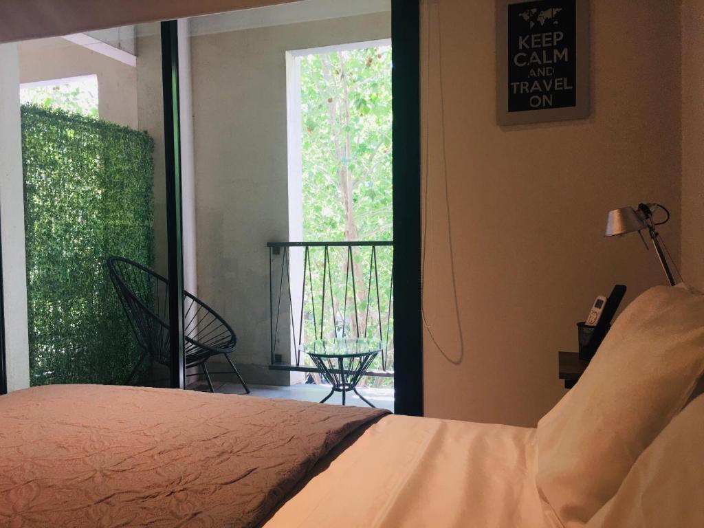 um quarto com uma cama e vista para uma varanda em Studio II em Belén de Escobar