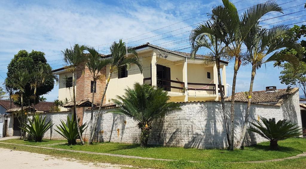 una casa con palme su un muro di Casa na praia do Indaia piscina, bilhar, 5 quartos e vista a Bertioga