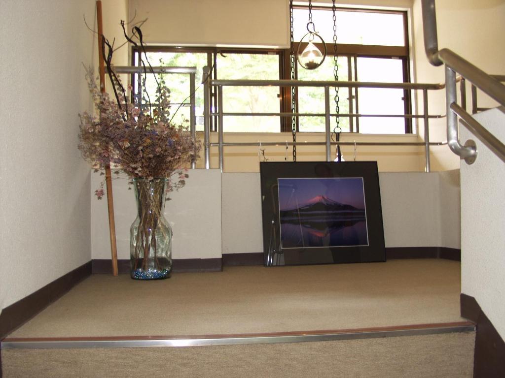 a room with a vase of flowers and a window at Teiensaryo Yamanakako in Yamanakako