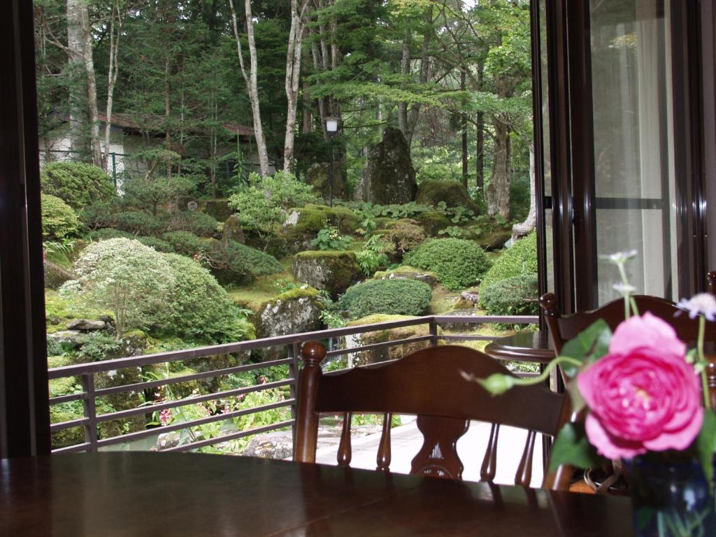 a view of a garden from a window with a flower at Teiensaryo Yamanakako in Yamanakako