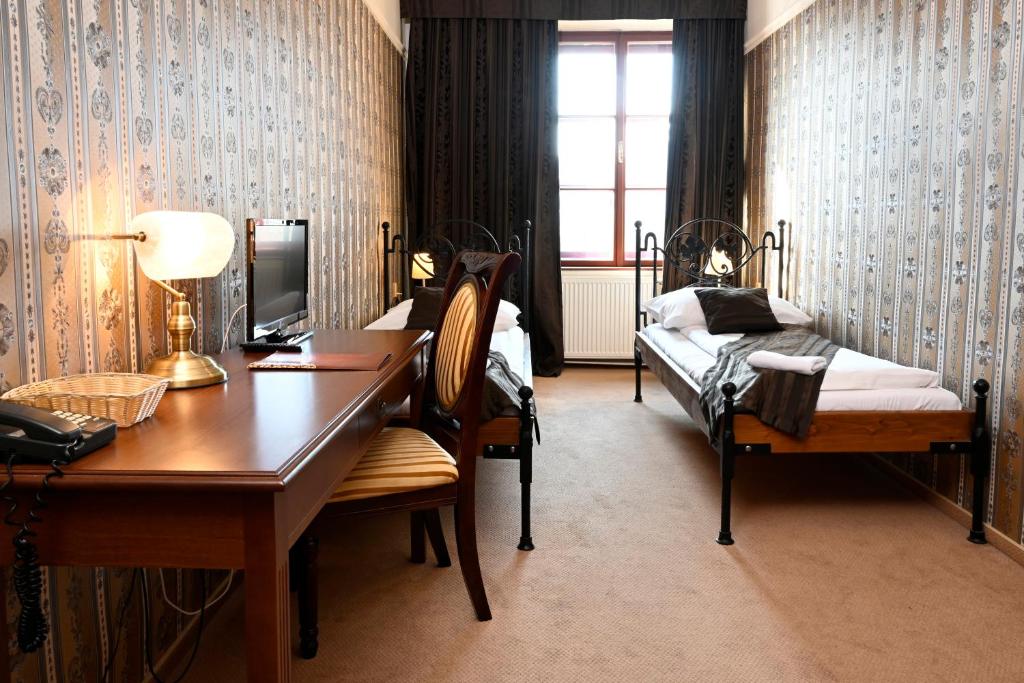 a bedroom with a desk and a bed and a desk sidx sidx sidx at Hotel Bouček in Kroměříž