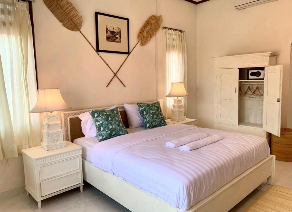 a bedroom with a white bed with two pillows at NIKINIKO Beach House by Lolavillas - 100mts to the beach in Canggu