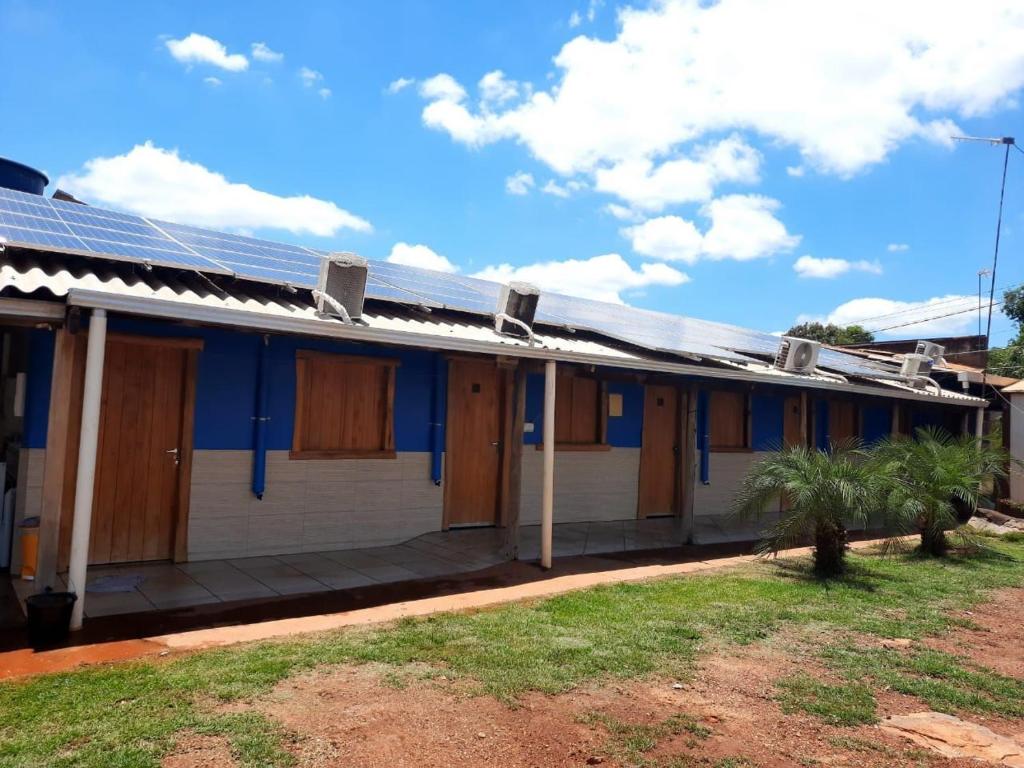 a blue and white house with solar panels on it at Agência e Pousada Estância da Mata in Estivado