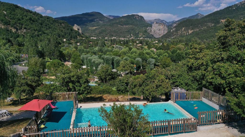 a large swimming pool with mountains in the background at Residence de Plein Air Panoramique à la Porte des Gorges du Verdon in Castellane