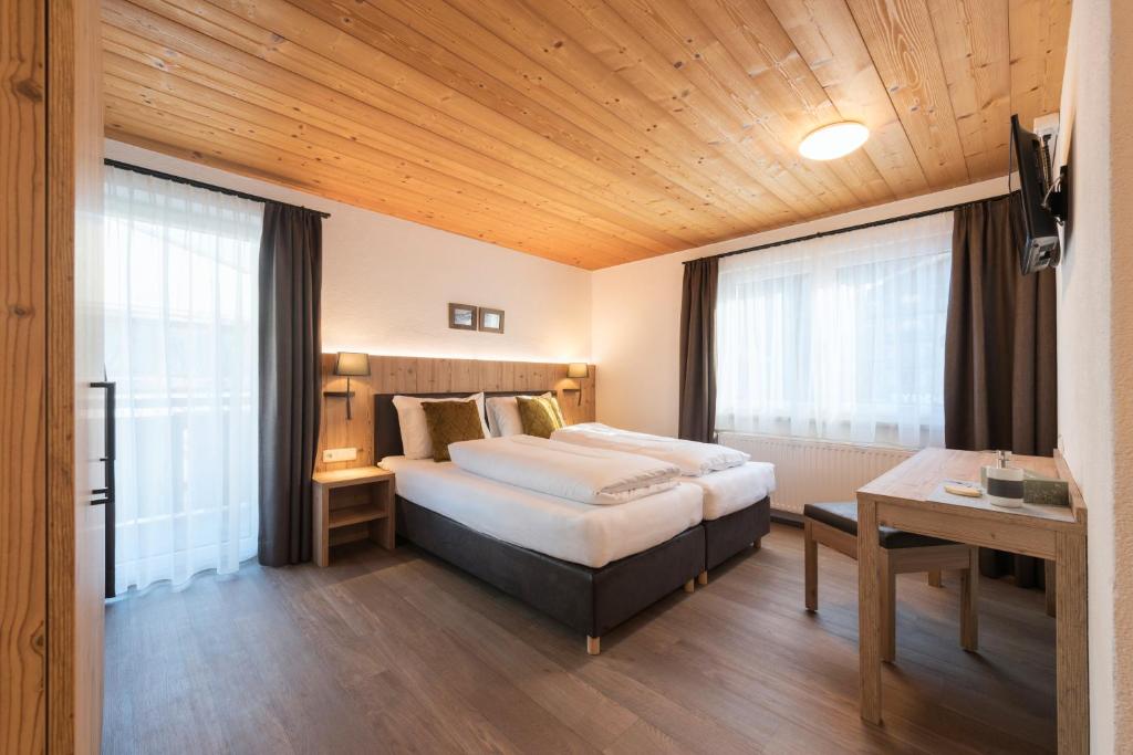 a hotel room with a bed and a table at Chalet Rosanna in Sankt Anton am Arlberg