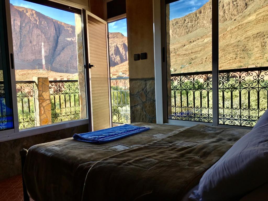 een bed in een kamer met uitzicht op de bergen bij La Petite Gorge, Hôtel & Restaurant Todra Gorge in Tinerhir