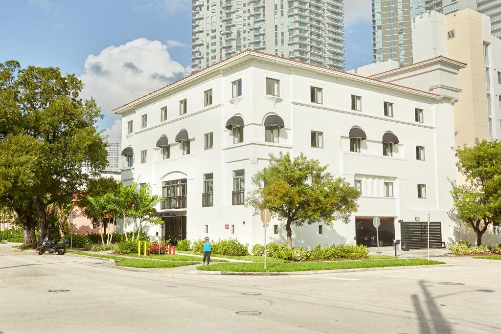 a white building with a person standing in front of it at Sonder The Palace in Miami