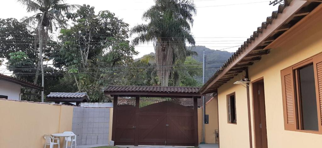 a brown garage door with a gate in a house at Recanto Primavera in Boicucanga