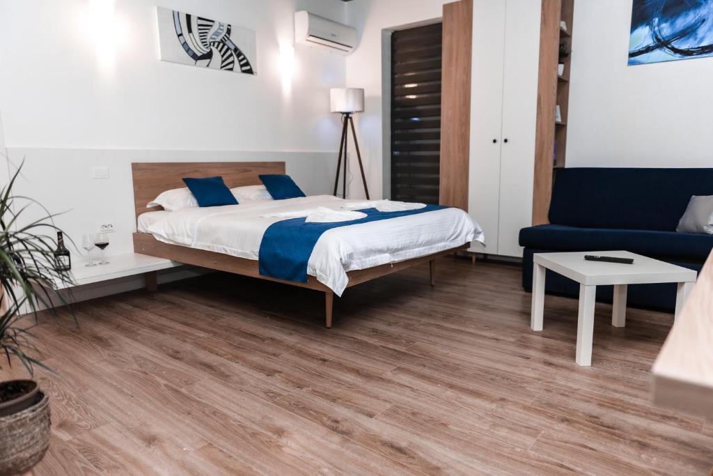a bedroom with a bed and a blue couch at Puzzle Apartaments&Studios in Craiova