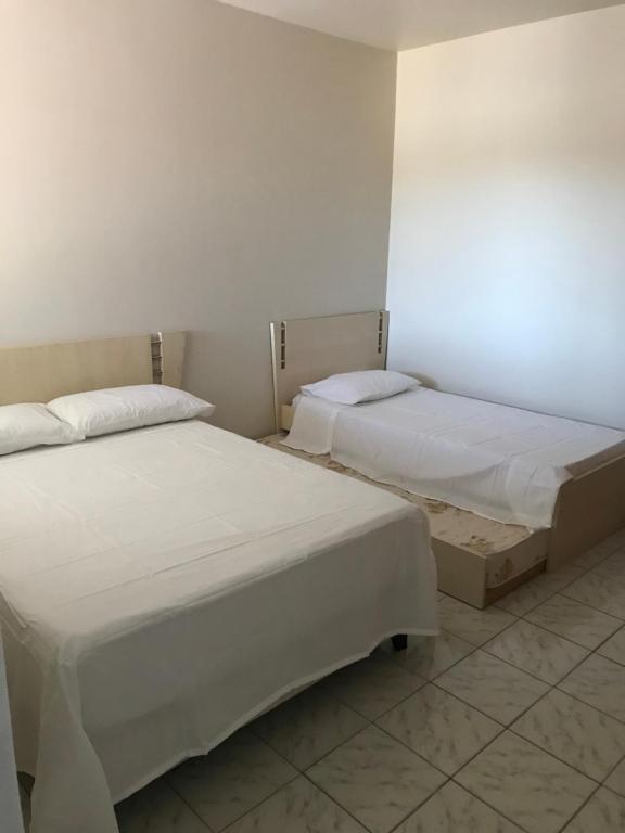 two beds sitting next to each other in a room at Apartamento foz centro 03 in Foz do Iguaçu