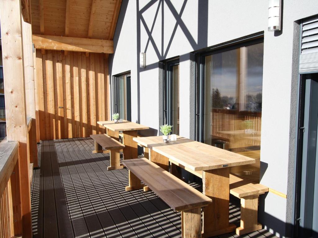 a deck with benches and tables on a building at Wooden chalet in Mauterndorf near Cross Country Meadows in Mauterndorf