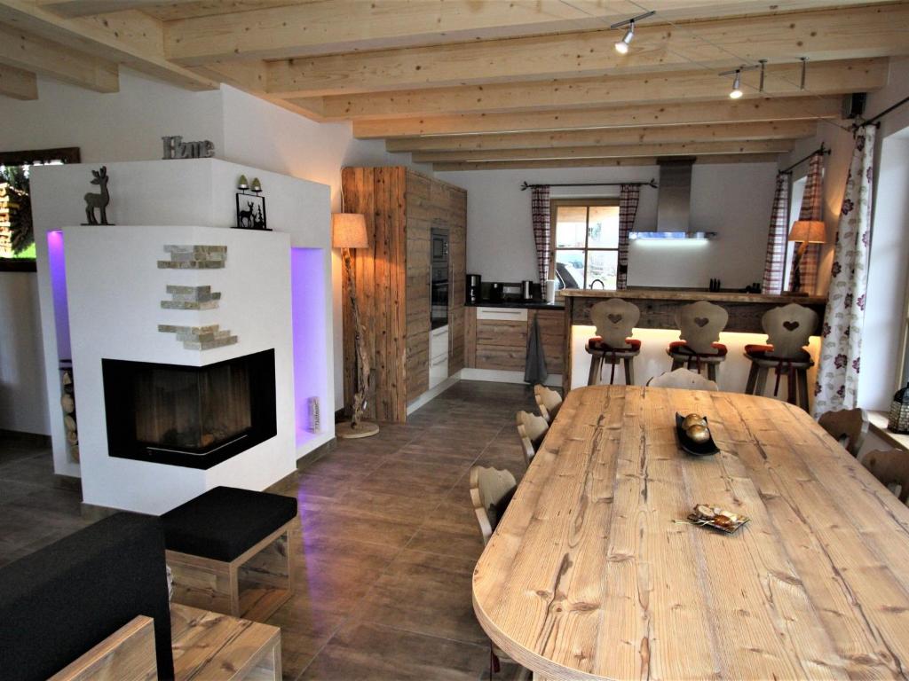 a living room with a wooden table and a fireplace at Modern chalet with garden in Salzburgerland near the Katschberg ski area in Sankt Margarethen im Lungau