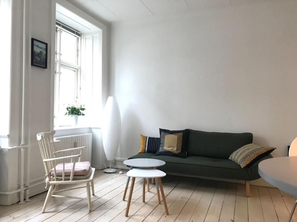 een woonkamer met een groene bank en een tafel bij ApartmentInCopenhagen Apartment 1183 in Kopenhagen