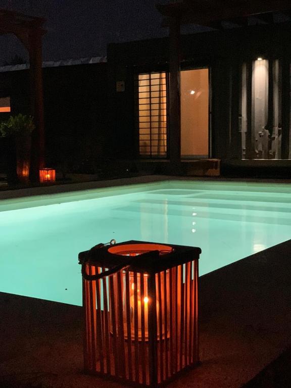 a trash can next to a swimming pool at night at Lo de Joaco y Marti in Punta Del Diablo
