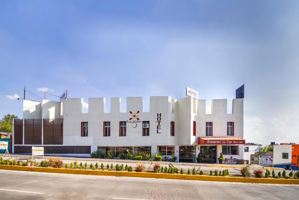un grand bâtiment blanc sur le côté d'une rue dans l'établissement Hotel Plaza Galindo, à San Juan de los Lagos