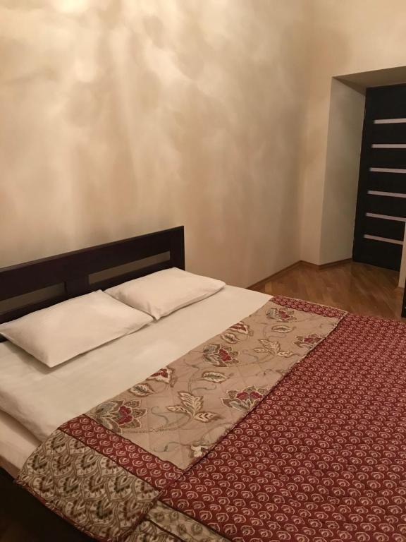 a bedroom with a bed with a red rug on it at Iren Lviv apartment in Lviv