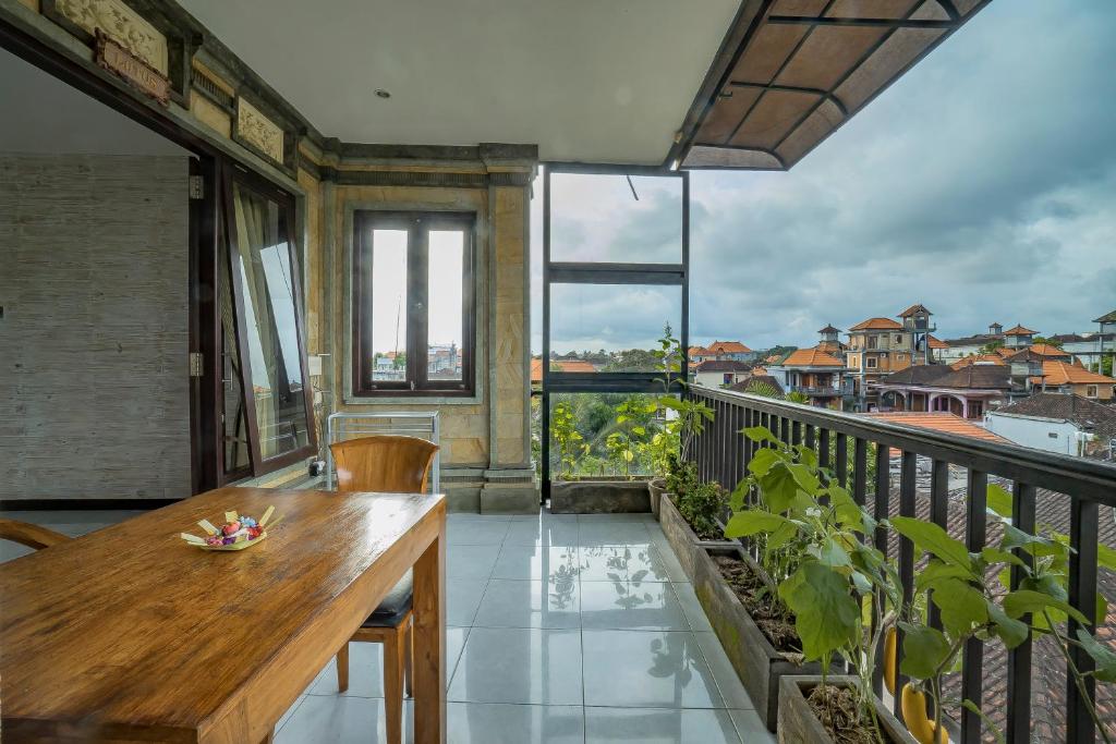 a balcony with a wooden table and a view at Iman Homestay Ubud in Ubud