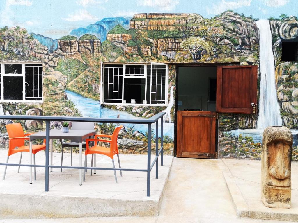 een muurschildering van een waterval en een tafel en stoelen bij Mountain Valley Stay - UNIT 3 in Nelspruit