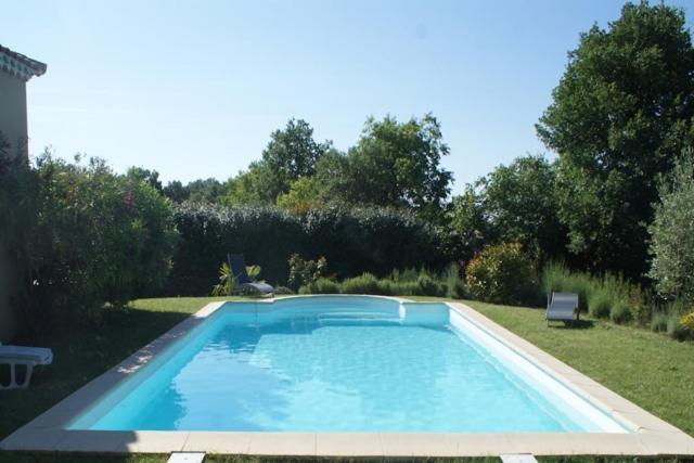 a large swimming pool in a yard with trees at VILLA EN CAMPAGNE POUR 8 PERS AVEC PISCINE PARC CLOTURE in La Capelle-et-Masmolène