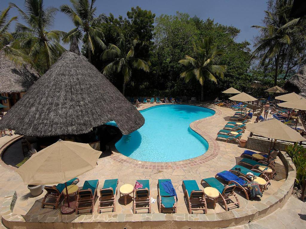 an overhead view of a swimming pool with chairs and umbrellas at Pinewood Beach Resort and Spa in Diani Beach