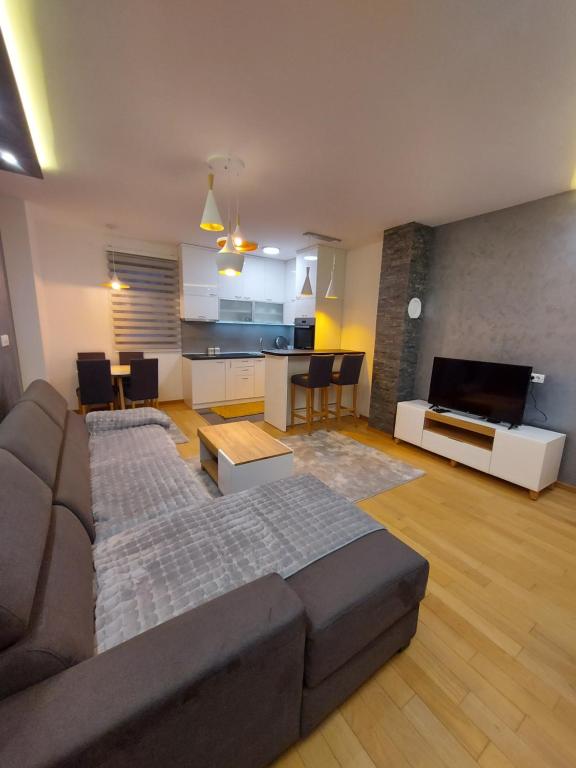 a large living room with a couch and a kitchen at Apartman Grey in Zlatibor