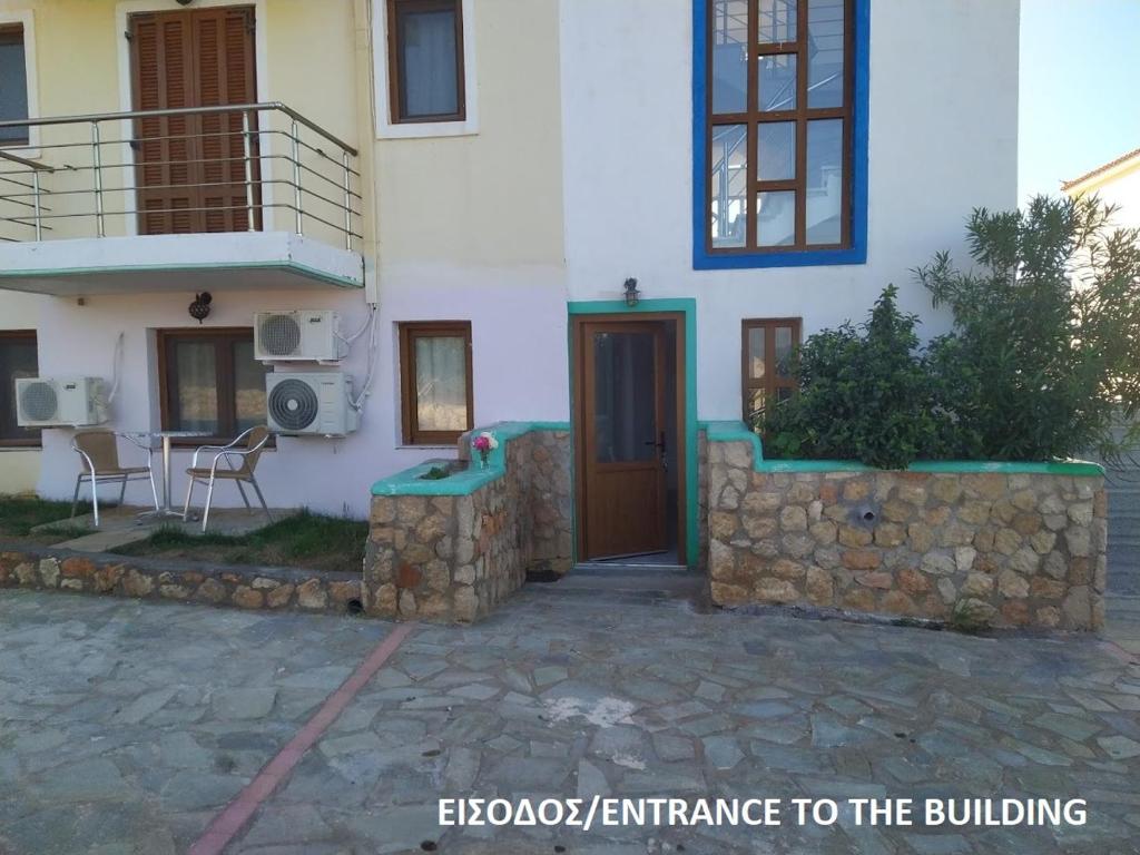 uma casa branca com uma porta e uma mesa em frente em Hotels Kalimera Inn em Elafonisos