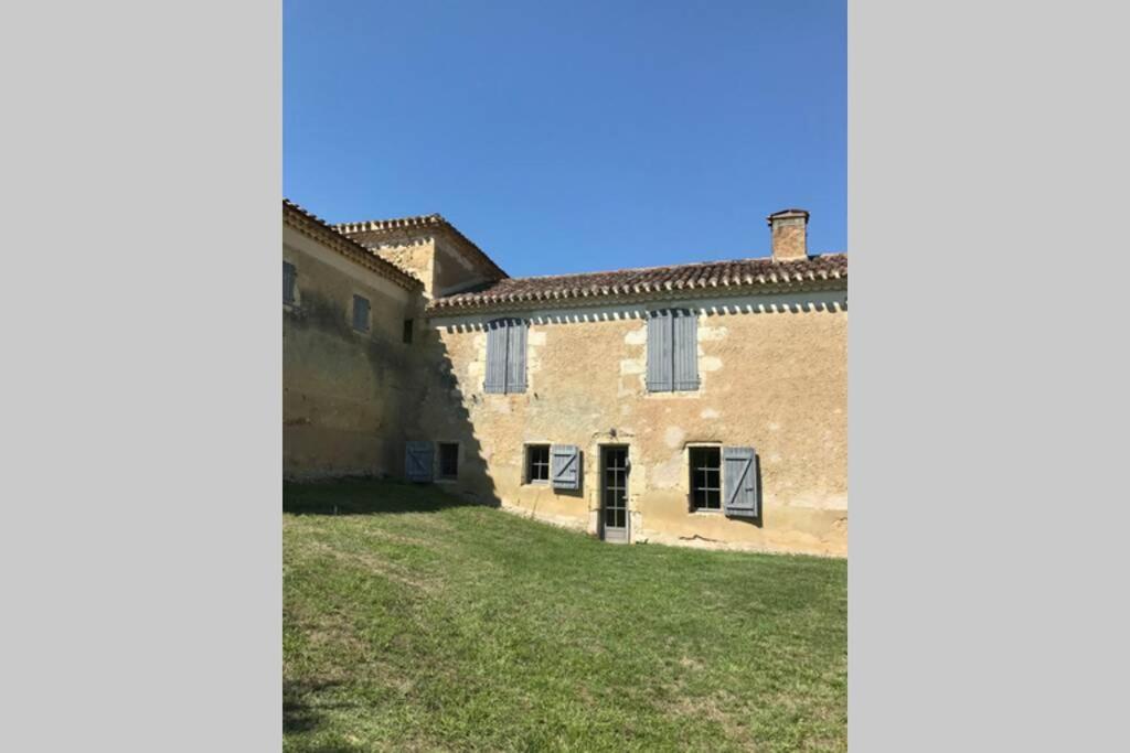 einem externen Blick auf ein Gebäude mit einem Hof in der Unterkunft Maison gasconne au calme au cœur du Gers in Duran