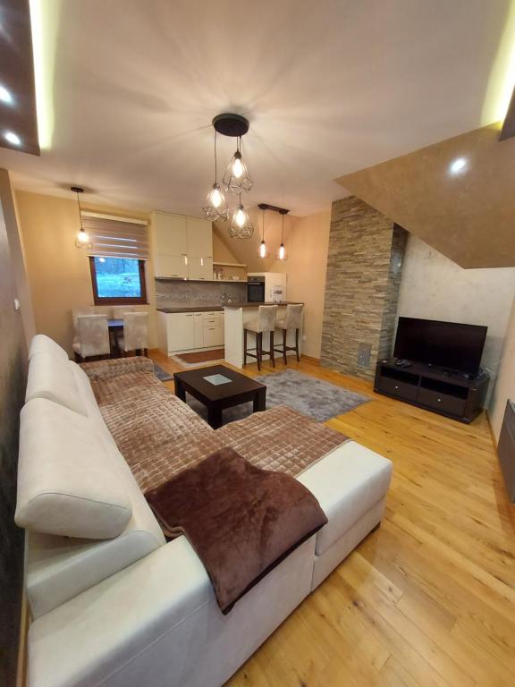 Il comprend un salon avec un canapé blanc et une cuisine. dans l'établissement Apartman Cream, à Zlatibor