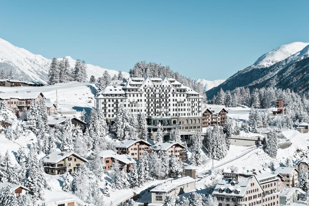 ein Resort in den schneebedeckten Bergen in der Unterkunft Carlton Hotel St Moritz - The Leading Hotels of the World in St. Moritz