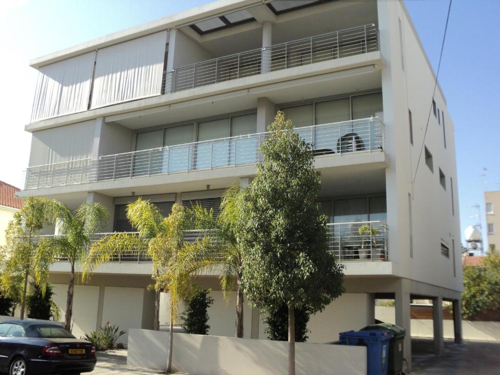 un edificio de apartamentos con un árbol delante de él en The Kapitani Residence, en Nicosia