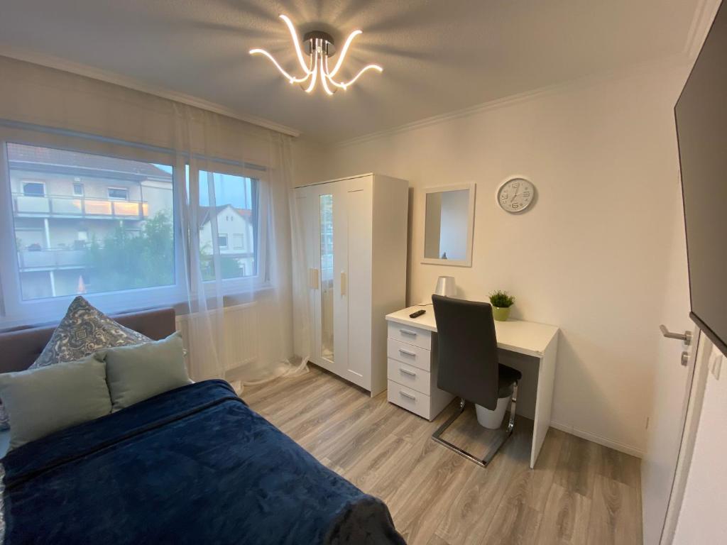 Schlafzimmer mit einem Bett und einem Schreibtisch mit einem Computer in der Unterkunft Work & Study Apartment in Karlsruhe