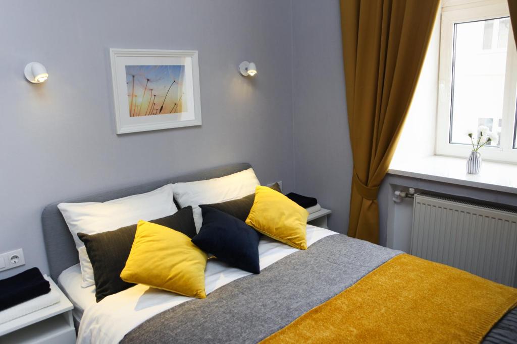 Hostel Krolichya Nora في كازان: غرفة نوم بسرير ومخدات صفراء وسوداء