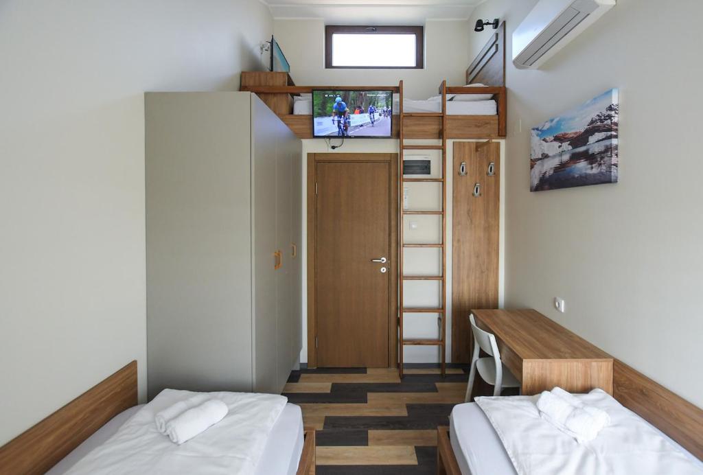 a small room with two beds and a tv at Hostel Atrijum in Kladovo
