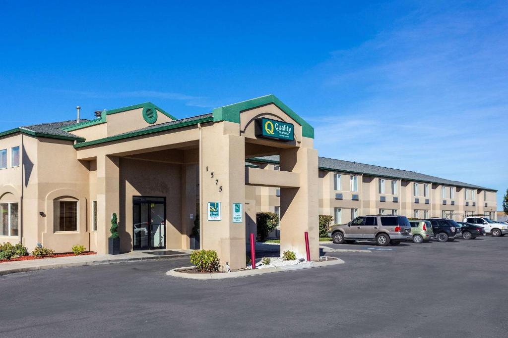a hotel building with a clock in a parking lot at Quality Inn & Suites in Meridian