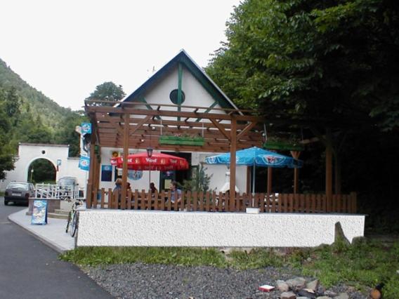 um pequeno edifício com um pavilhão com dois guarda-sóis em Restaurace a pension První Mlýn Chomutov em Chomutov