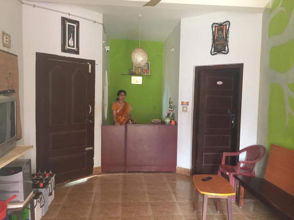 a woman standing in a room with two doors at Doctors Heritage Lodge in Sringeri