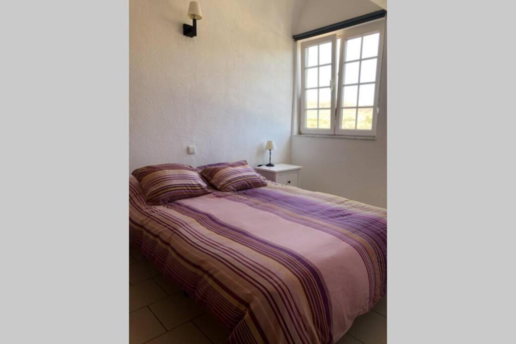 Bett in einem Zimmer mit Fenster und Tagesdecke in der Unterkunft Apartamento en La Pared Fuerteventura vista mar in Pájara
