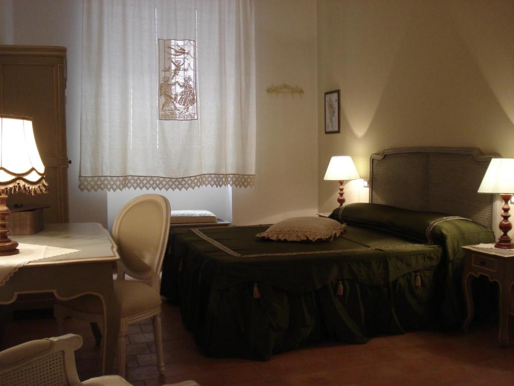 a bedroom with a bed and a desk and a chair at Residenza Levante in Syracuse