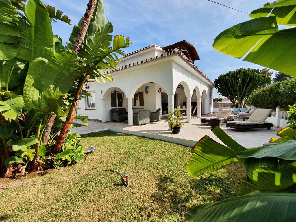 a white house with a patio and a yard at Casa Blue Vista, beachside villa in Marbella