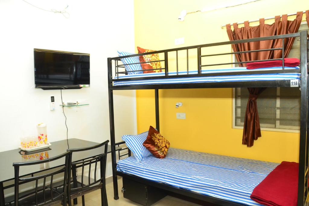 een kamer met 2 stapelbedden, een tafel en een bureau bij Tranquil AC Budget Room( Single, Family & Group) in Bhubaneshwar